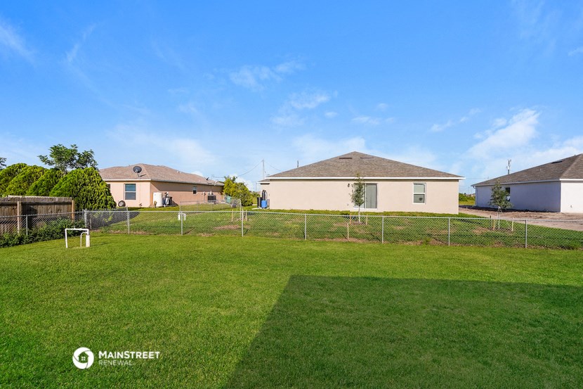 a backyard with a soccer field and two houses in the background