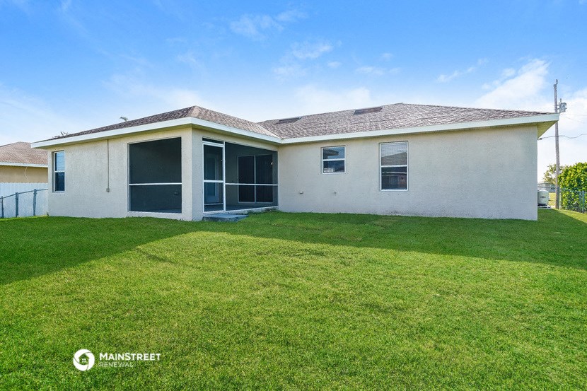 a white house with a grass yard and a lawn