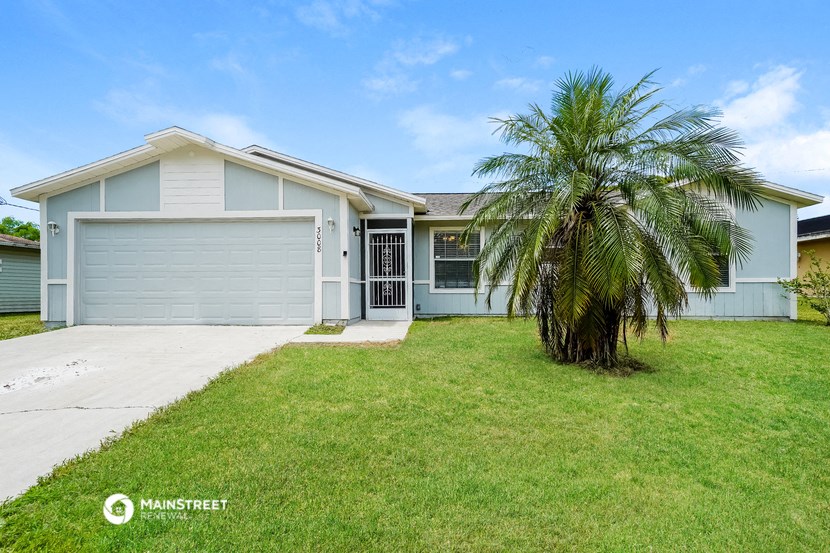 a blue house with a palm tree in front of it