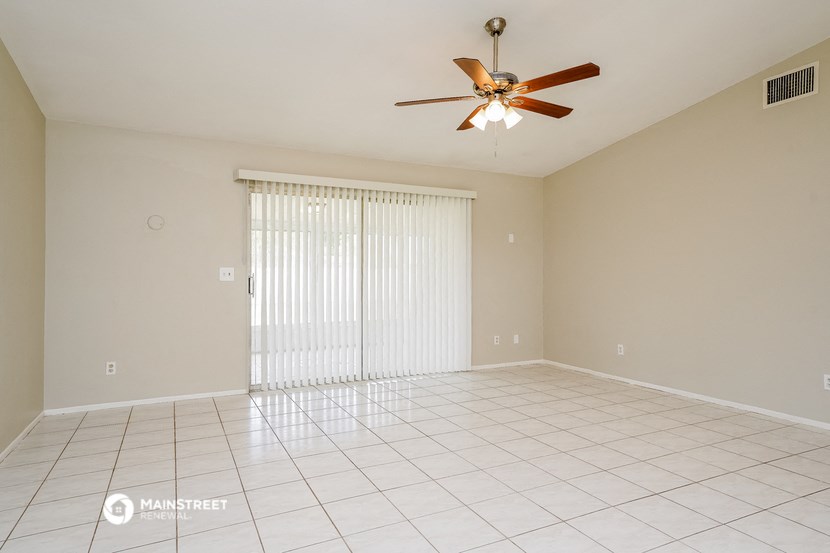 the spacious living room with sliding glass doors to the patio