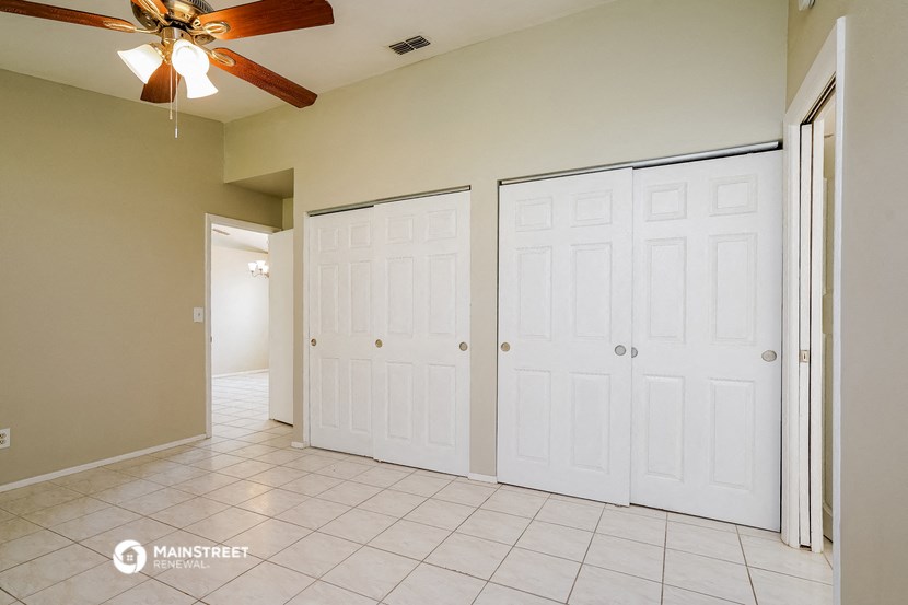 an empty room with two closets and a ceiling fan