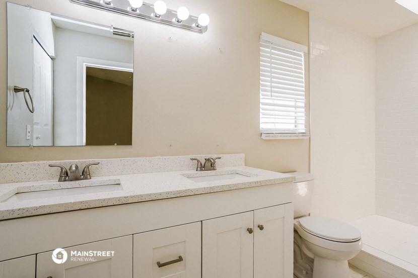a bathroom with two sinks and a mirror and a toilet