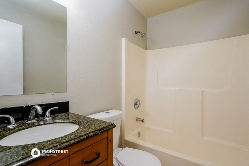 a bathroom with a sink toilet and shower and a mirror