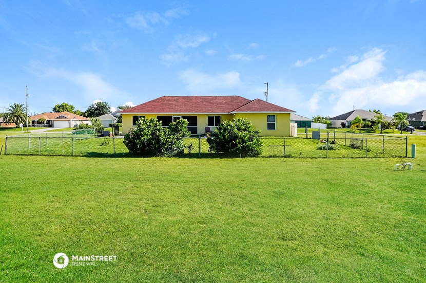 a house with a yard and a fence in front of it