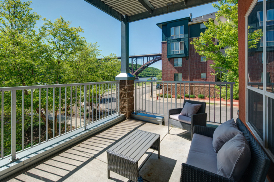 Personal balcony with patio chairs and a table, overlooking the lake