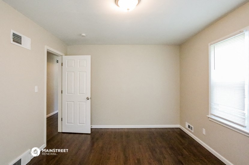 the living room of an empty house with a white door