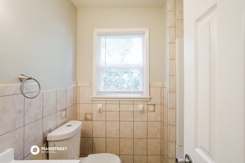 a bathroom with a toilet and a window