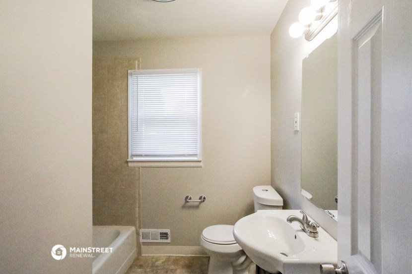 a bathroom with a sink and a toilet and a mirror