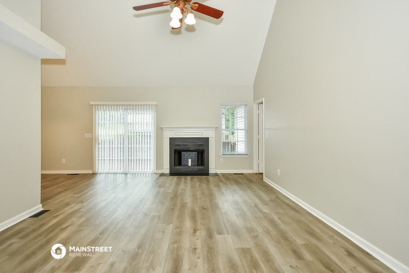 the living room with wood flooring and a fireplace