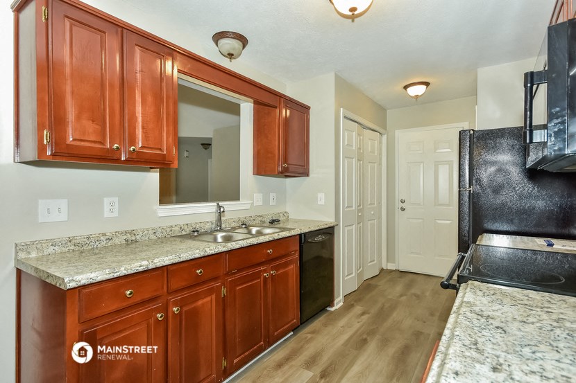 a kitchen with wood cabinets and granite counter tops and a sink