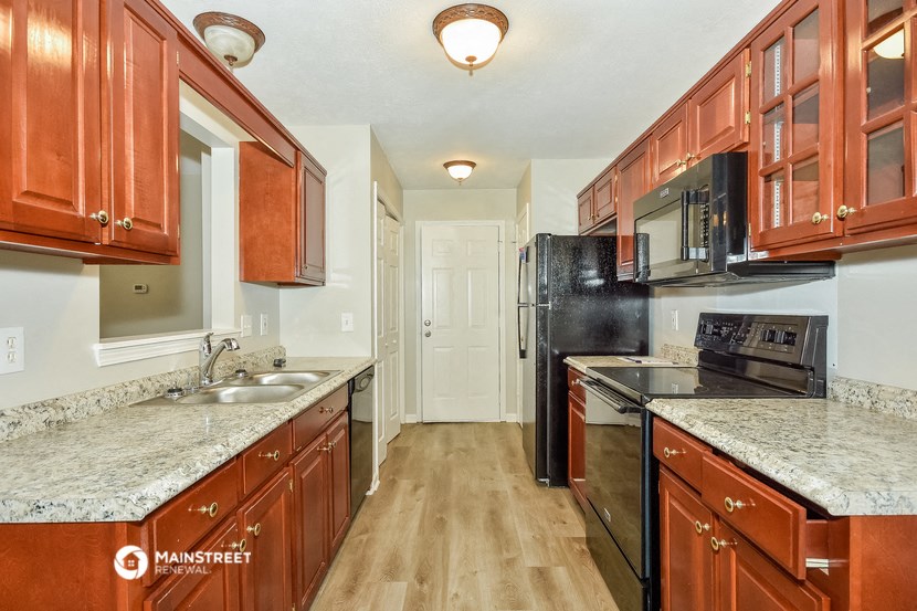 a kitchen with wood cabinets and granite counter tops and black appliances