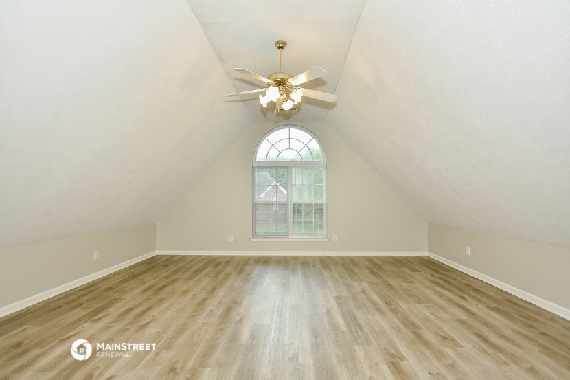 the master bedroom has a vaulted ceiling and hardwood floors