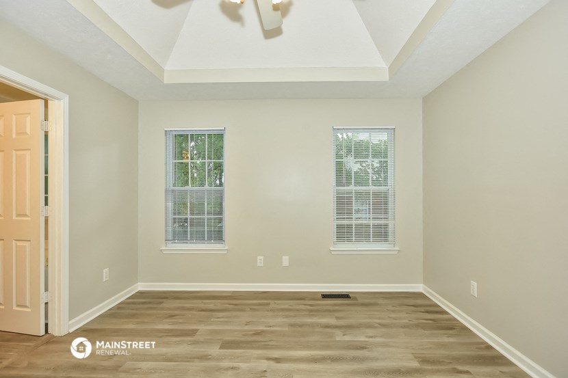 the spacious living room with hardwood floors and a vaulted ceiling