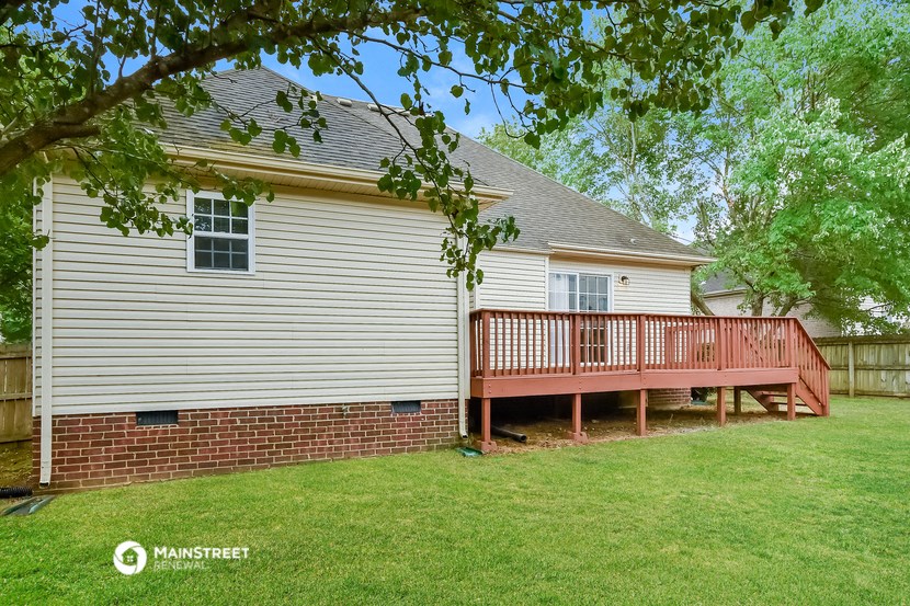 the back of the house with a wooden deck