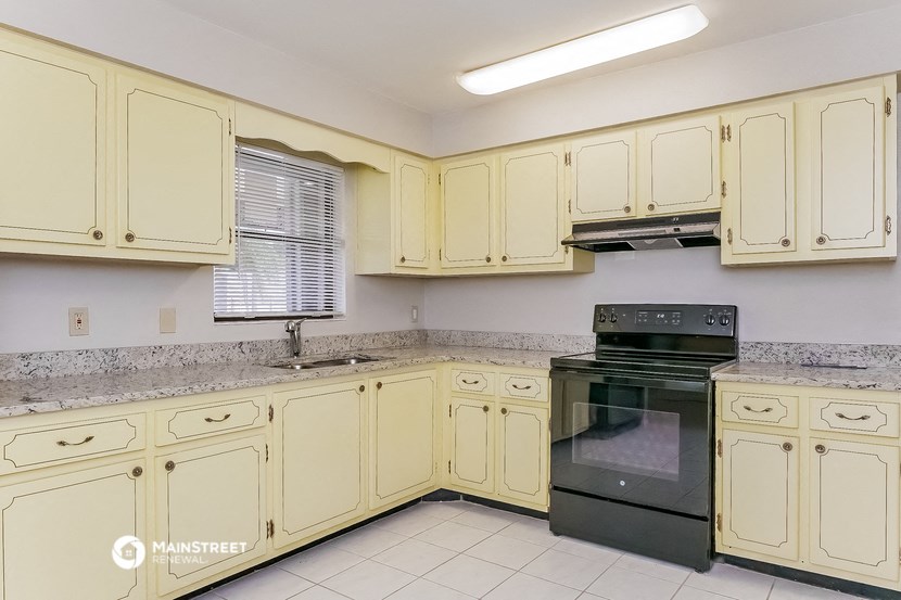 a kitchen with white cabinets and black appliances and a sink