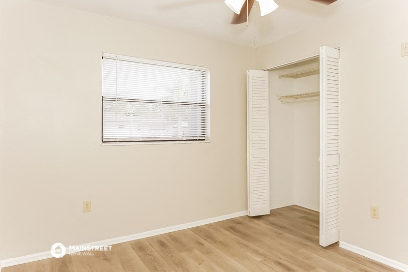 a bedroom with a door to a closet and a window