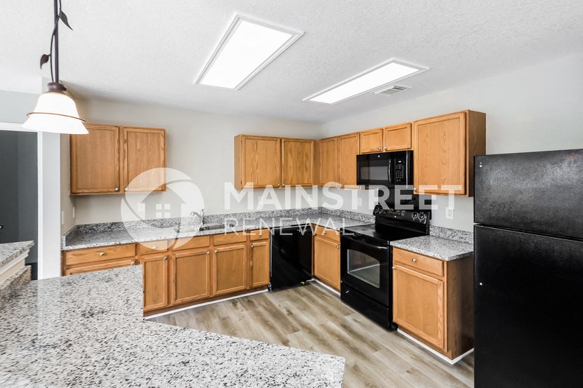 a kitchen with granite counter tops and wooden cabinets