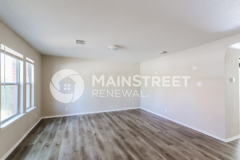 a living room with a hardwood floor and a window