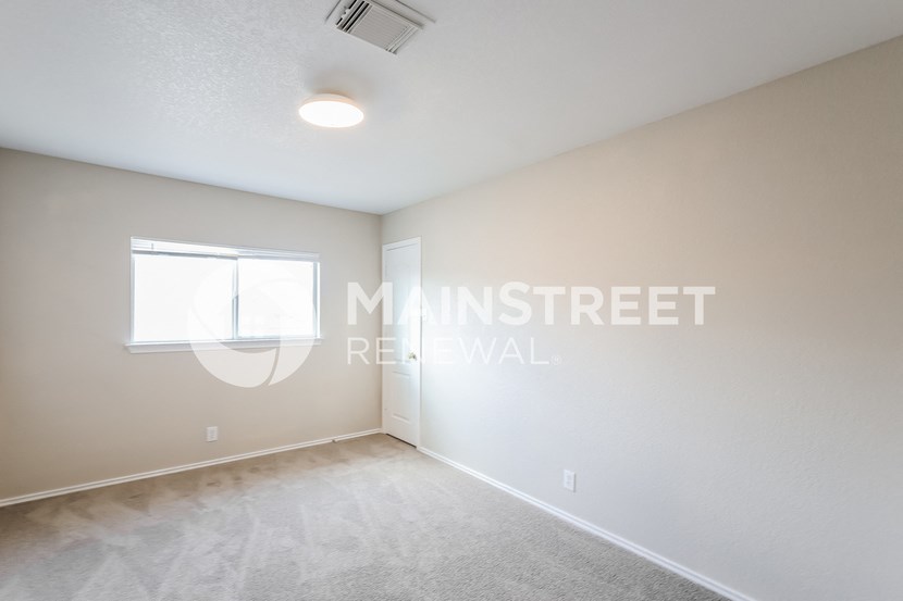 a bedroom with a carpeted floor and a window