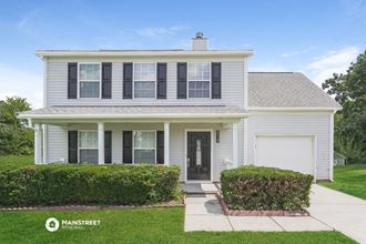a white house with black window shutters and a white driveway