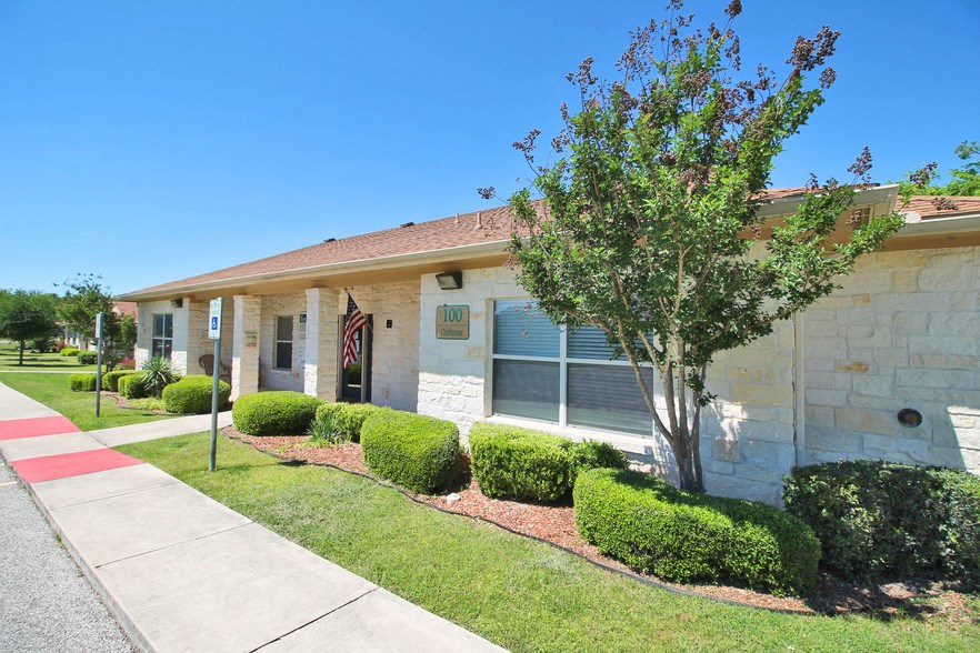 a white house with a tree and a sidewalk in front of it