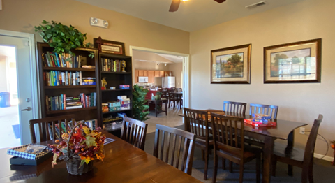 a dining room and living room with a table and chairs and a bookshelf