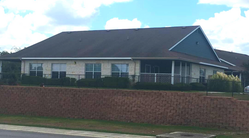 a house with a black roof and a brick wall