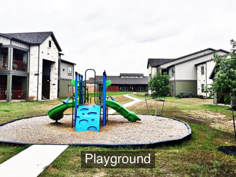 a playground in a yard with houses in the background