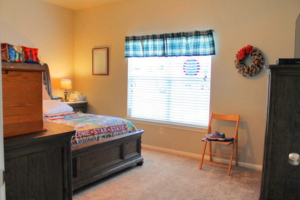 a bedroom with a bed and a dresser and a window