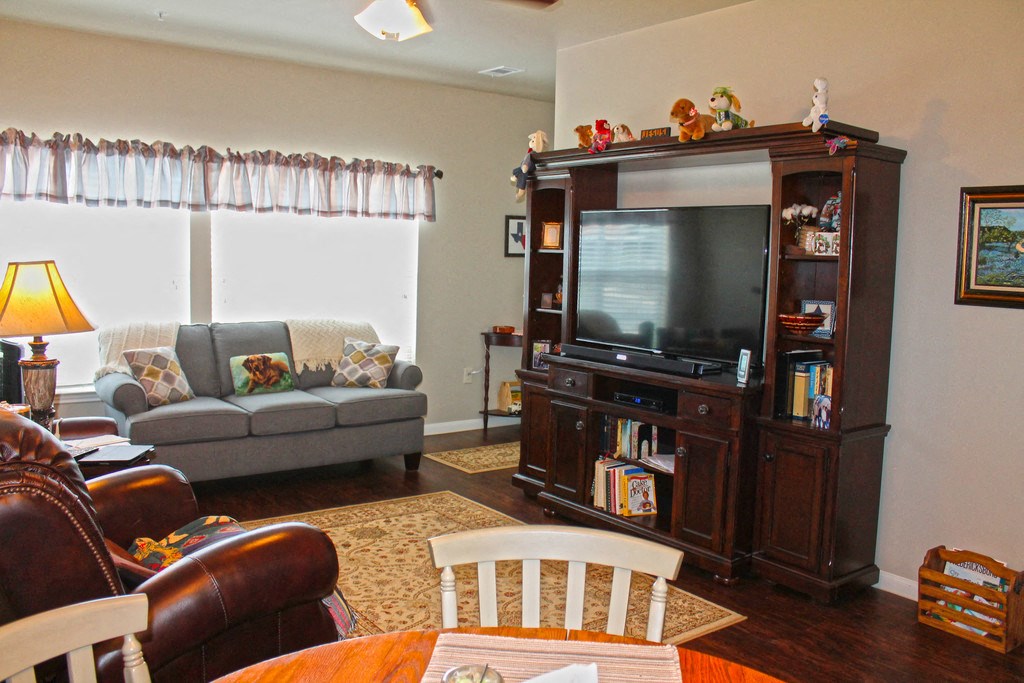 a living room with a tv and a table and chairs