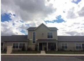a large house with a cloudy sky in the background