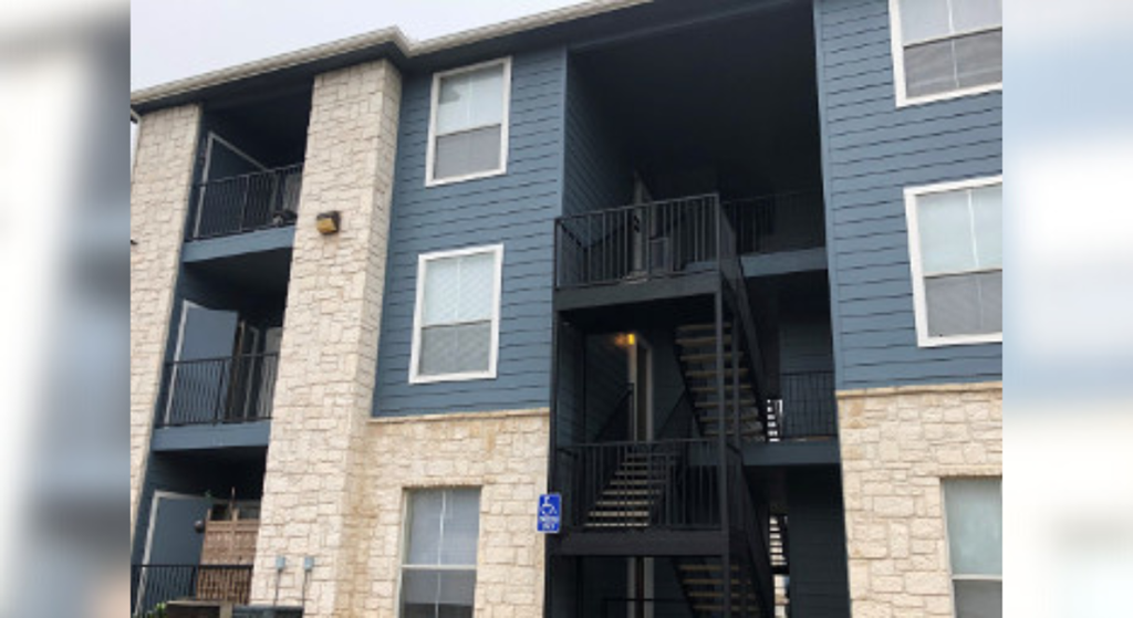 an apartment building with two balconies and a stone facade