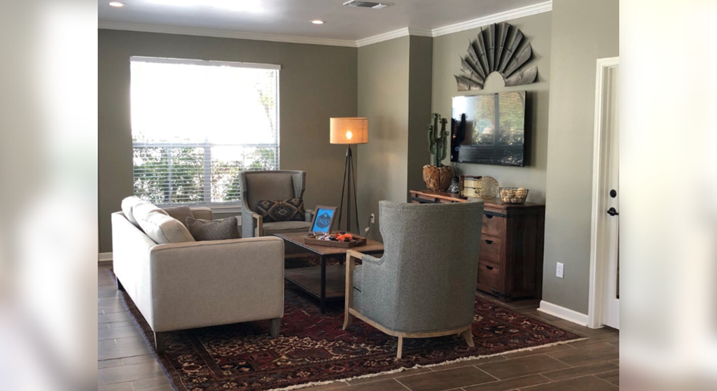 a living room with couches and chairs and a rug