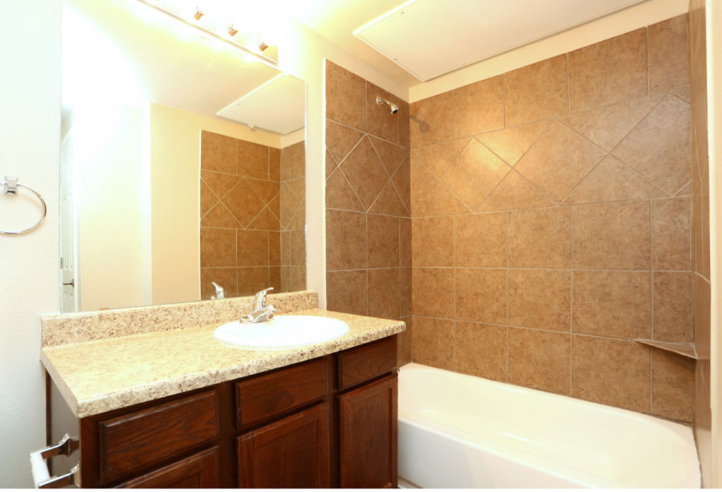 a bathroom with a sink and a tub and a mirror
