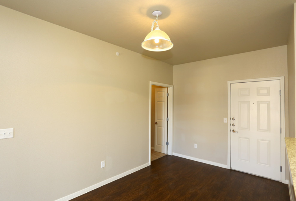 the view of a living room with a door to a hallway and a white door