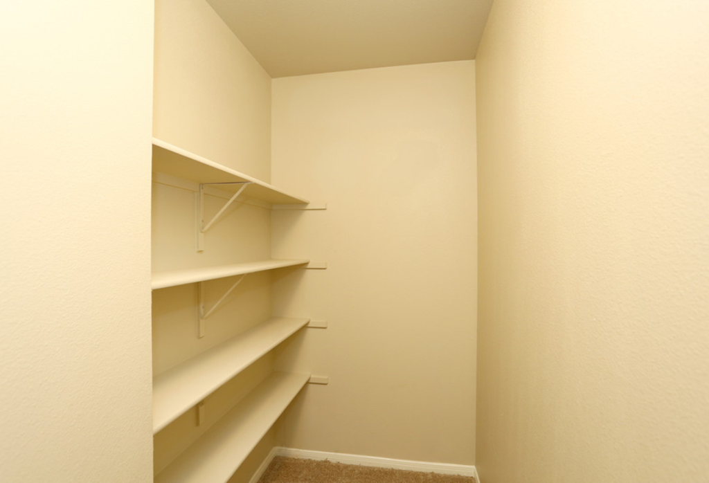 a walk in closet with shelves and empty shelves