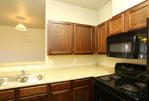 a kitchen with a counter top and a stove and a microwave