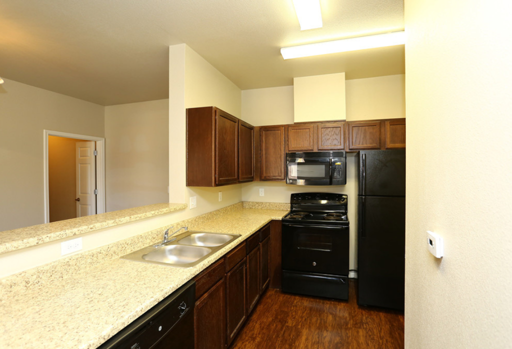 a kitchen with granite counter tops and black appliances
