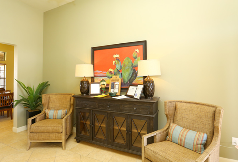 a living room with two chairs and a table with two lamps