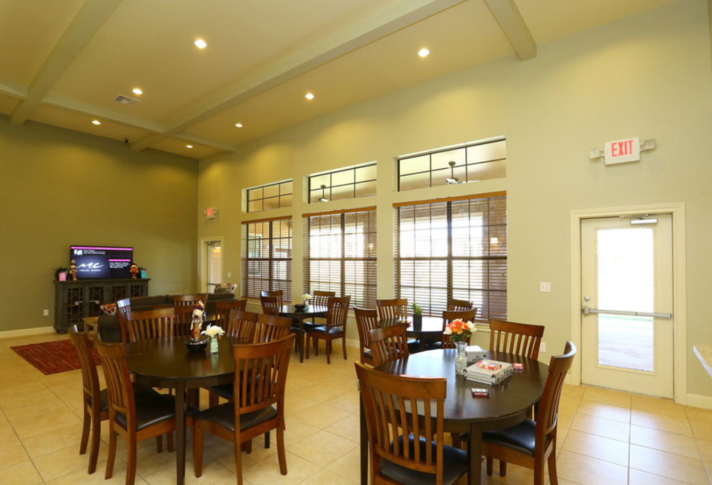 a dining room with tables and chairs and large windows