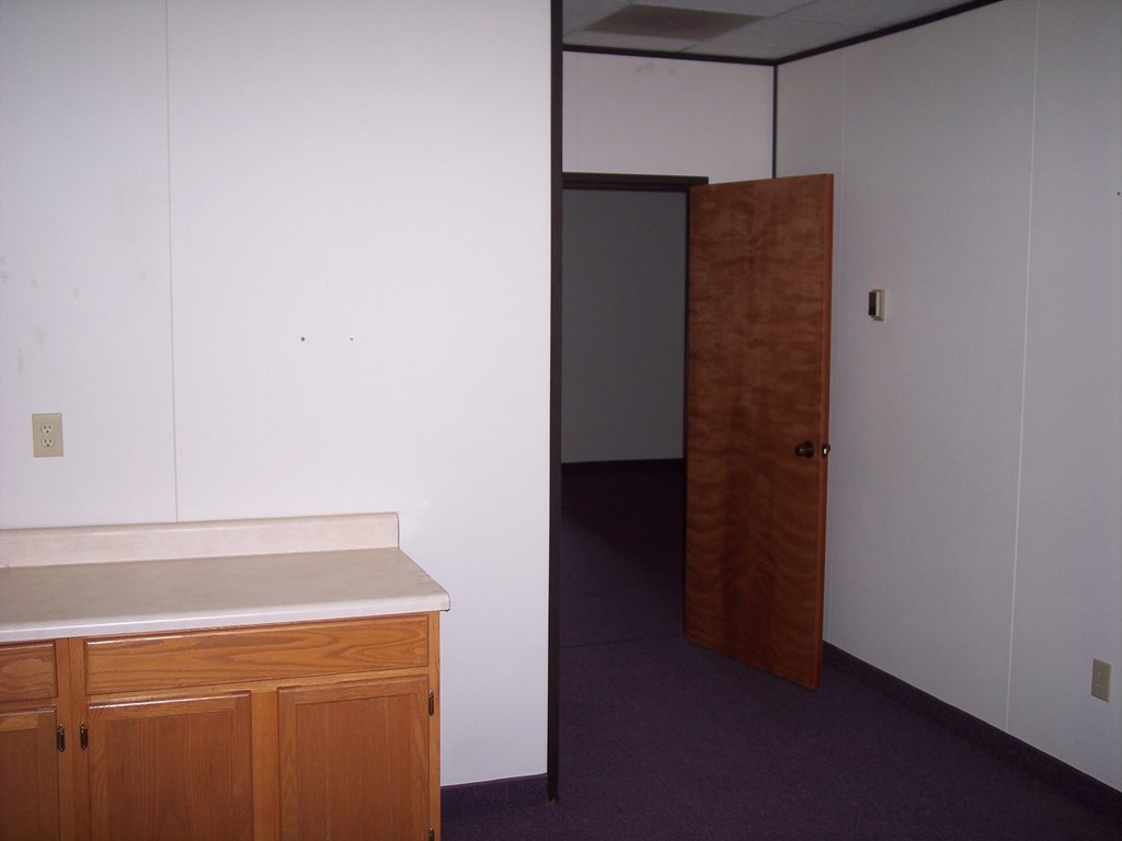 an empty room with a counter and a door