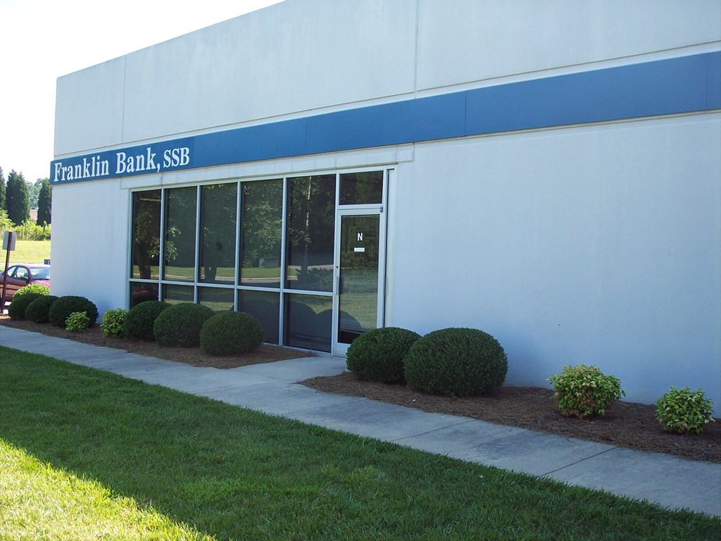 a white building with a blue sign on the side of it