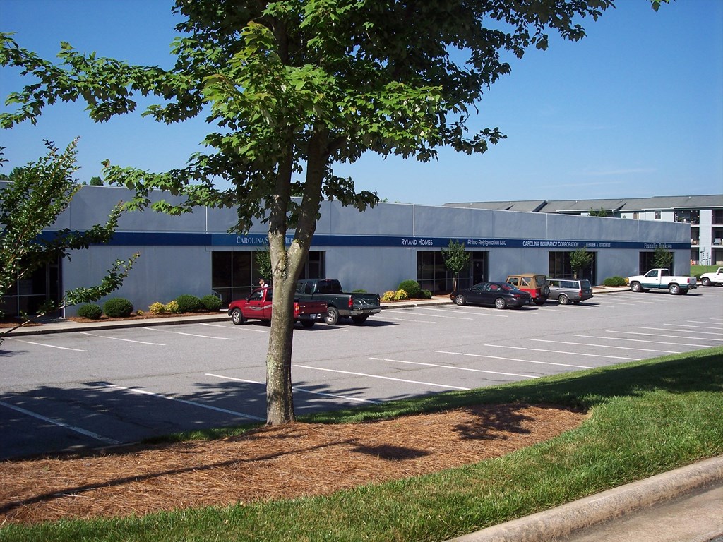 a parking lot with cars in front of a building