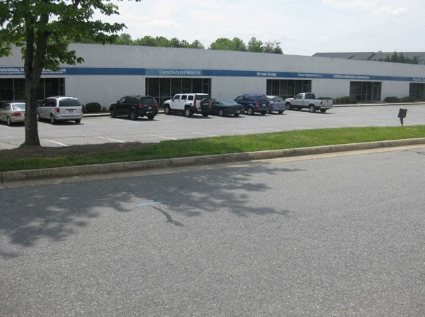 a parking lot with cars parked in front of a building