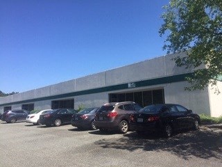 A parking lot with cars and a building in the background.