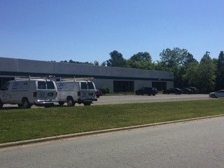 A building with a row of vans parked in front.