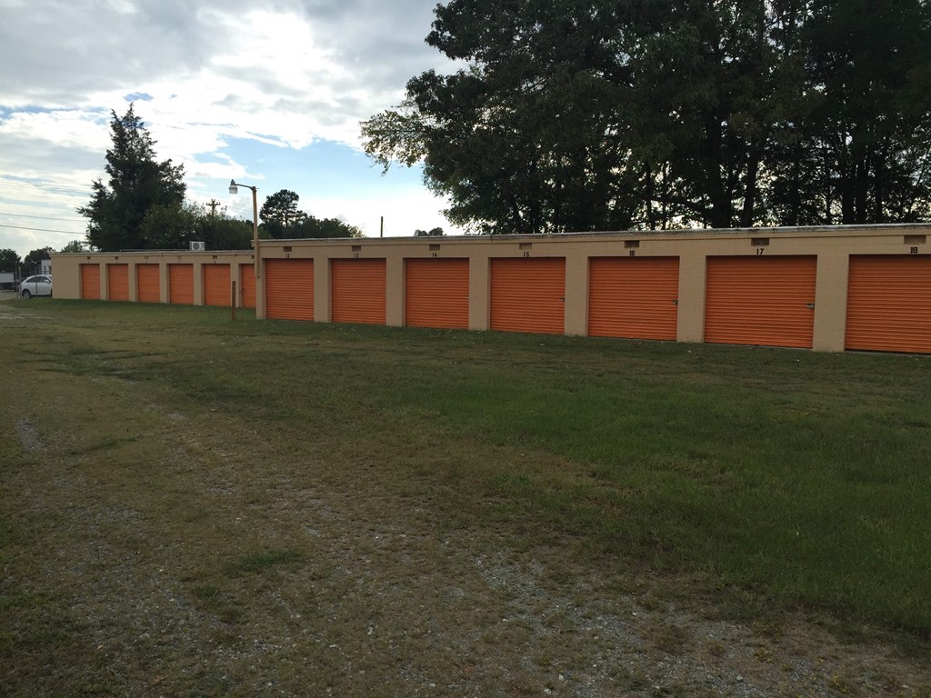 a row of orange roll up garage doors on a building