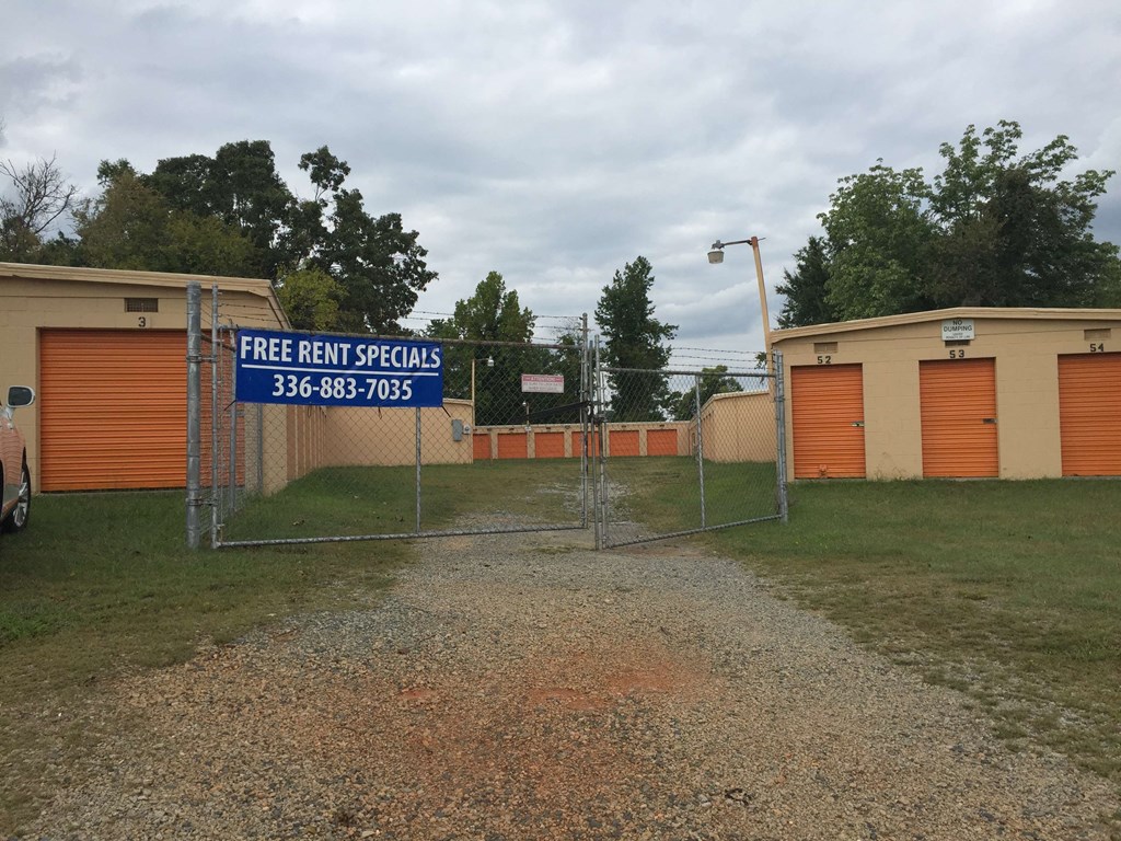a yard with a fence and a sign that reads free rent specials