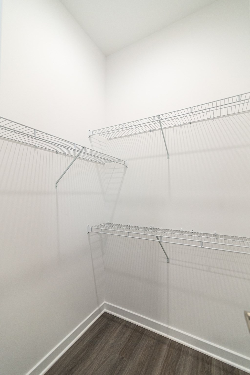 room with white walls and a white closet with metal shelves