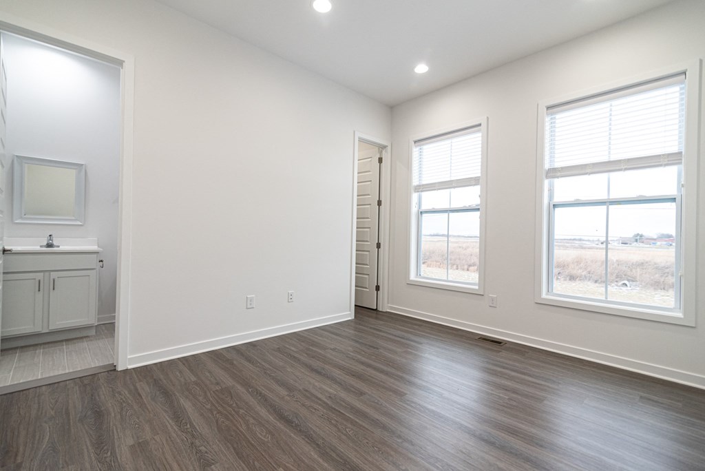 an empty living room with white walls and wood flooring